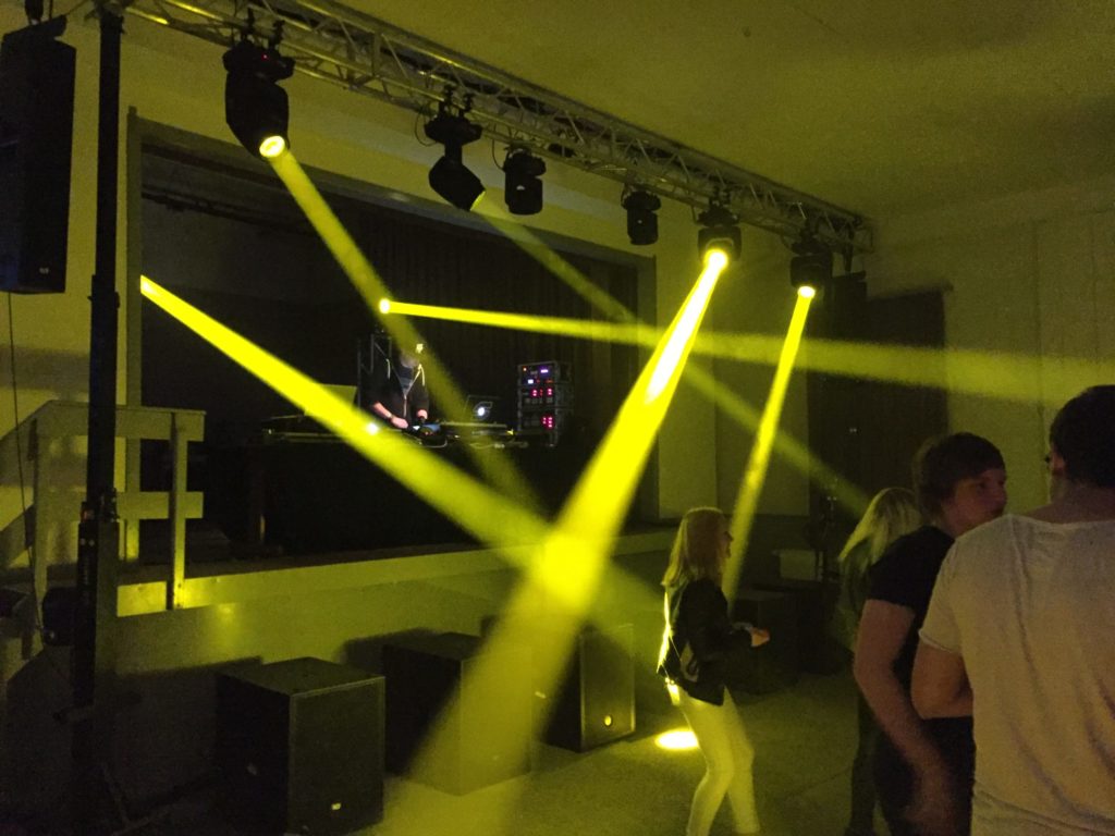 Moving Heads mit gelben Lichtstrahlen bei einer Party