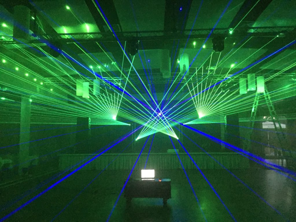 Lasershow mit grünen und blauen Fächern in einer Halle